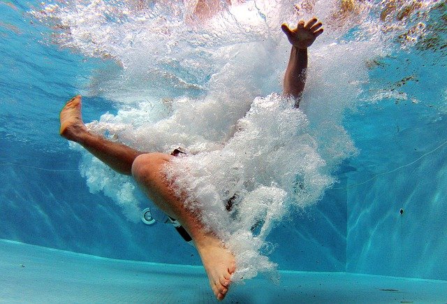 člověk potápějící se v bazénu